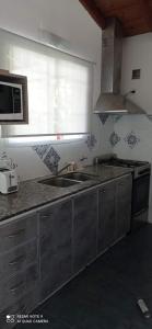 a kitchen with a sink and a microwave at Chalet de 2 dorm- 1baño - Piscina in Valeria del Mar