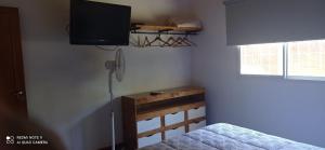 1 dormitorio con 1 cama y TV de pantalla plana en Chalet de 2 dorm- 1baño - Piscina en Valeria del Mar