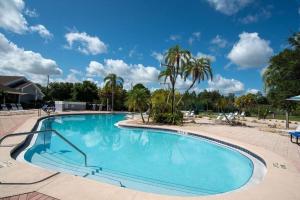 a large blue swimming pool with palm trees in the background at Cozy Studio Apartment close to Disney in Davenport