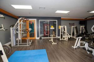 a gym with several treadmills and machines in a room at Cozy Studio Apartment close to Disney in Davenport