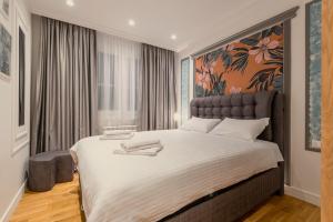 a bedroom with a large bed with a large painting on the wall at Modern Harmony in Kolašin