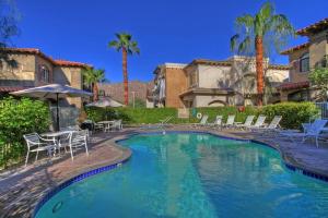 uma piscina com cadeiras e mesas e palmeiras em CLR109 Charming 1 Bedroom Overlooking the Pool em La Quinta