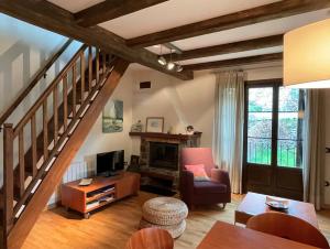 a living room with a staircase with a couch and a chair at CHECK-IN CASAS Casa Plaza Mayor in Villanova