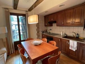 a kitchen with a wooden table and some chairs at CHECK-IN CASAS Casa Plaza Mayor in Villanova