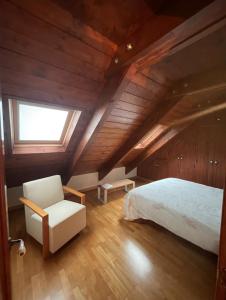 una camera da letto con un letto, una sedia e una finestra di CHECK-IN CASAS Casa Plaza Mayor a Villanova