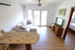 a living room with a couch and a tv at New One Bedroom Suite West Bay Roatan - Number 6 in West Bay