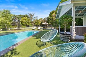 a yard with two chairs and a swimming pool at Allambea Mount Eliza in Mount Eliza