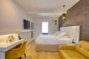 リールにあるBoa Hotel - BW Signature Collection - Lille Centre Garesの白いベッドとソファが備わるホテルルームです。