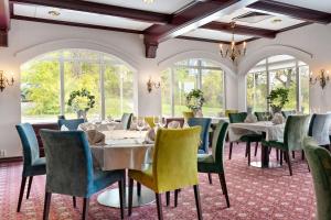 uma sala de jantar com mesas, cadeiras e janelas em Best Western Royal Star em Estocolmo