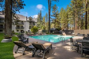 a swimming pool with chairs and a table at Best Western- Big Bear Chateau in Big Bear Lake