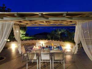 una zona pranzo all'aperto con tavolo e sedie di notte di Athiri House Villa Corfu a Spartýlas