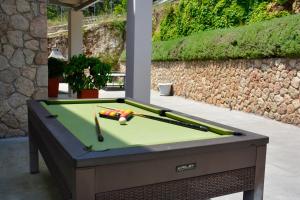un tavolo da biliardo seduto in un cortile con una piscina di Athiri House Villa Corfu a Spartýlas