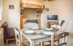 ein Esszimmer mit einem Tisch mit Stühlen und einem TV in der Unterkunft 2 Bedroom Beautiful Home In Penvenan in Penvénan