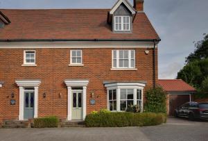 a brick house with a car parked in front of it at Elizabeth Townhouse Braintree 