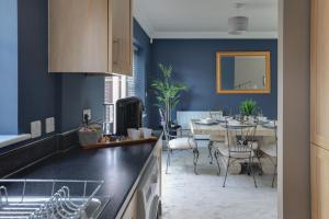 uma cozinha com paredes azuis e uma sala de jantar em Elizabeth Townhouse Braintree 