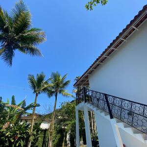 eine Treppe, die zu einem Haus mit Palmen führt in der Unterkunft Casa da Praia Juquehy JQY in Juquei