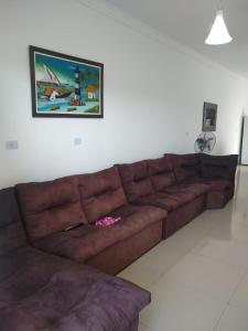 - un canapé brun dans le salon avec une photo sur le mur dans l'établissement Casa Nova com Piscina 3 quartos, à Guaratuba