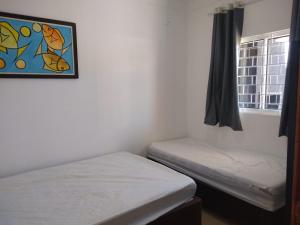 - une chambre avec 2 lits jumeaux et une fenêtre dans l'établissement Casa Nova com Piscina 3 quartos, à Guaratuba