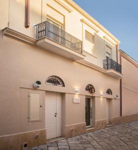un edificio con un balcón en el lateral. en Filia Solis - Old Town SUITEs & SPA, en Brindisi