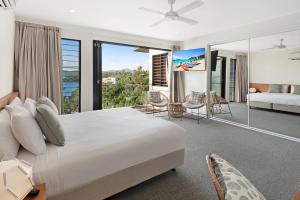 a bedroom with a bed and a view of the ocean at Hidden Cove on Hamilton Island by HIHA in Hamilton Island