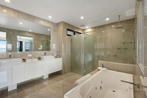 a bathroom with two sinks and a tub and a shower at Hidden Cove on Hamilton Island by HIHA in Hamilton Island