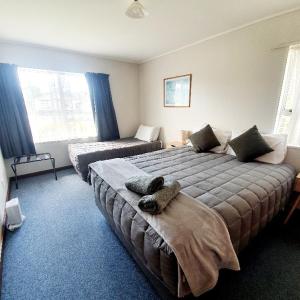 a hotel room with two beds and a bed and a bed at Chanel Court Motel in Masterton