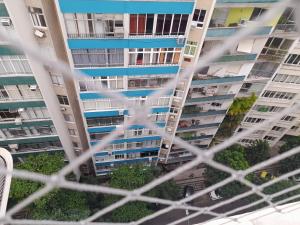 a view of a tall apartment building from a window at Quadra Praia, Posto 4, Split, smarttv Cabo, wifi , 35m2 in Rio de Janeiro
