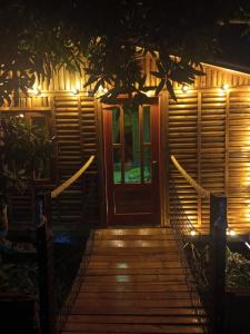 un camino de madera que conduce a una puerta por la noche en la casita del arbol guaduas cundi. en Guaduas