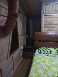1 dormitorio con 1 cama en una cabaña de madera en la casita del arbol guaduas cundi. en Guaduas