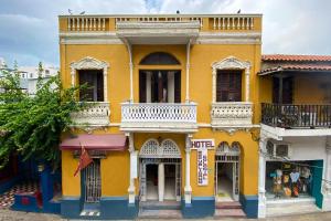 un edificio amarillo con balcón en una calle en Hotel Ayenda Republicano Colonial No 2, en Santa Marta