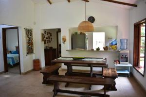 ein Esszimmer mit einem Holztisch und Bänken in der Unterkunft Finca Milandia in Villeta