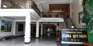un vestíbulo con escaleras y un cartel en un edificio en Flora Quy Nhon Hotel, en Quy Nhon