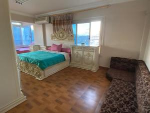 a bedroom with a bed and a couch and windows at شقه مطله علي قناة السويس والبحر فيو رائع 702 بورسعيد in Port Said