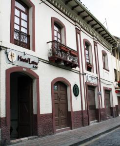 um edifício com portas castanhas numa rua em Hostal Latina em Cuenca
