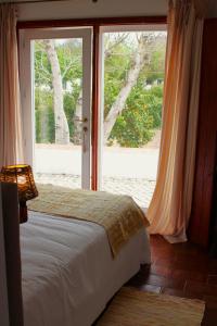sypialnia z łóżkiem przed oknem w obiekcie Horta das Laranjas w mieście Serpa