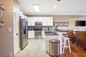 a kitchen with white cabinets and a stainless steel refrigerator at Baja Breeze in Port Aransas
