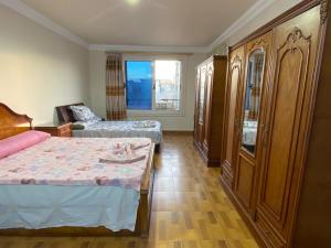 a bedroom with two beds and a couch and a window at شقه مطله علي قناة السويس والبحر فيو رائع 702 بورسعيد in Port Said
