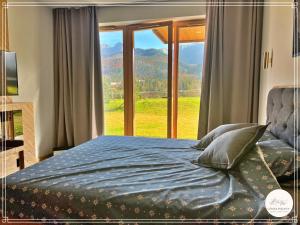 sypialnia z łóżkiem i dużym oknem w obiekcie Górska Enklawa w mieście Kościelisko