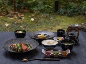 una mesa con platos de comida y tazones de comida en Mitsui Garden Hotel Kyoto Sanjo, en Kioto