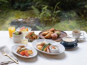 a table topped with plates of food and cups of coffee at Mitsui Garden Hotel Kyoto Sanjo in Kyoto