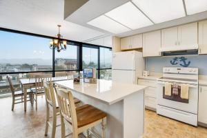 a kitchen with white appliances and a table with chairs at Sand & Sea: The Holladay (418) in Seaside