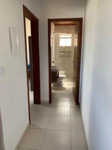 a hallway of a bathroom with a toilet and a sink at Ocean Residence in Palhoça