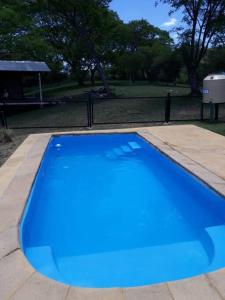 una piscina azul en un parque en Los Petti casa de campo en Salta