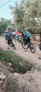 a group of people riding bikes on a dirt road at Dar Tadout in Aït Ourir