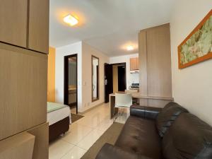 a living room with a couch and a bedroom at The Sun Full Condominium Resort in Brasília