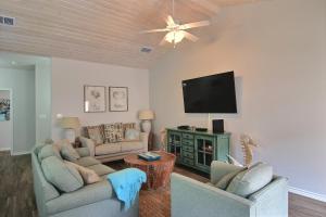 a living room with two couches and a flat screen tv at Port A Good Time in Port Aransas