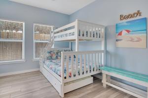 a white crib in a room with a bunk bed at Fin And Tonic in Port Aransas