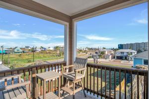 a balcony with a chair and a view of the street at Fin And Tonic in Port Aransas