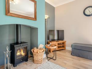 a living room with a fireplace and a couch at Brickyard Cottage in Metheringham