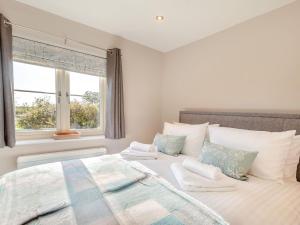 a bedroom with a large bed and a window at Brickyard Cottage in Metheringham
